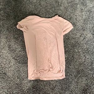 Blush pink top says shipwreck near the collar